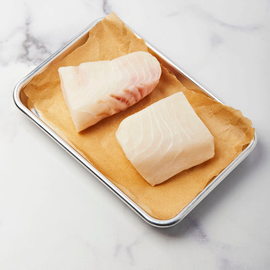 Raw halibut on a sheet pan waiting to be cooked