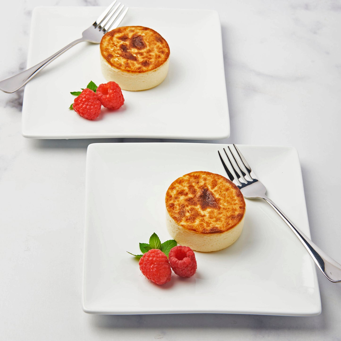 2 Crème Brulee Cheesecakes on plates ready to be eaten