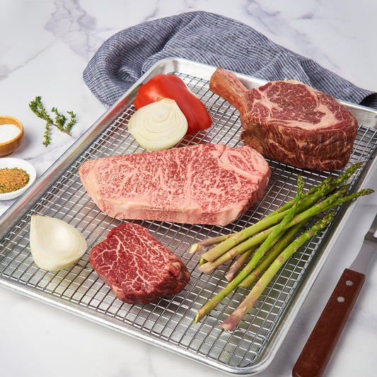 Raw American Full-blood cowboy Ribeye, A5 Japanese New York Strip and Australian Wagyu filet on a rack ready to be cooked