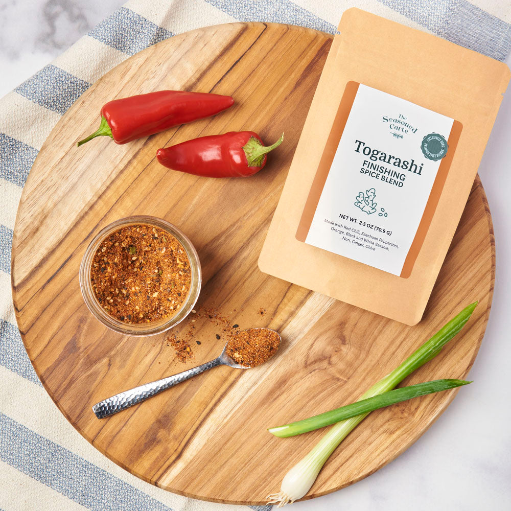 Package of Togarashi Finishing Spice Blend on a cutting board with a bowl, ready to be used.