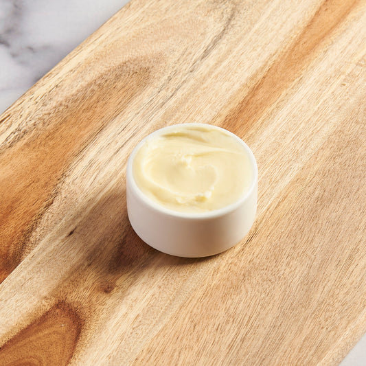 Small bowl of butter on a cutting board.