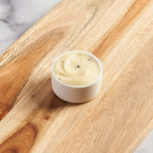 Small bowl of butter on a cutting board.