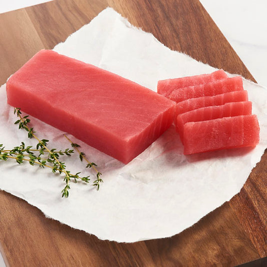 Raw ahi tuna on a cutting board ready to be prepared and cooked.